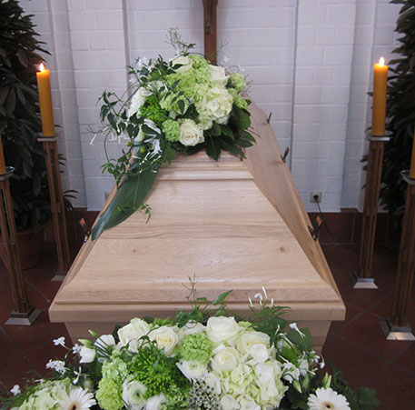 Sarg mit weißen und grünen Blumen